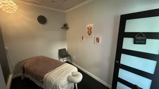 The treatment room from the door, with the table, a chair and the frosted glass door